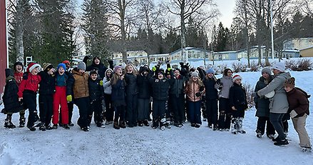 en stor grupp barn står på en skolgård