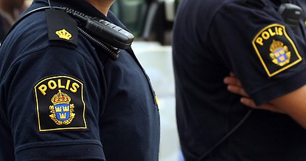 Närbild på två oidentifierbara poliser där texten "POLIS" syns på deras uniformer.