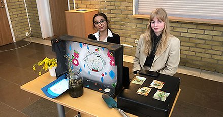 elever i en samlingssal på en skola, visar hållbara lösningar vid bord