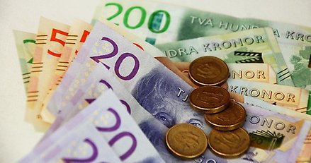 flera sedlar och mynt ligger på ett bord