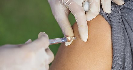 närbild på överarm på en person som får en spruta