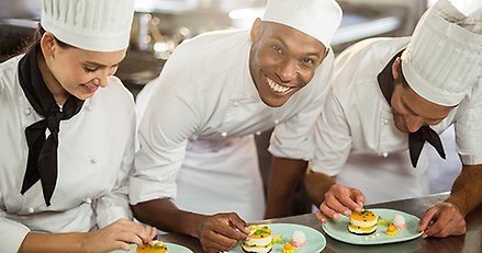 Tre kockar som lagar mat.