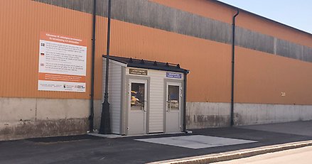 mot en orange vägg finns en liten tillbyggnad med två glasdörrar.