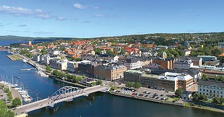 flygbild över en stad med en bågbro inmonterad över ett sund