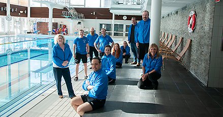 en grupp människor vid kanten av en simbassäng