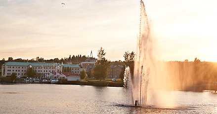 fontän i vattnet med hus i bakgrunden