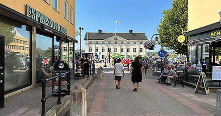 Trädgårdsgatan i Härnösand. Gågata med människor. Till vänster ett café till höger en restaurang.
