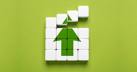 En bild av tärningar som lagda tillsammans bildar en grön pil som pekar uppåt.