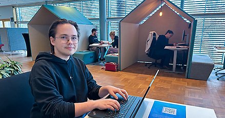 en ung man sitter vid en dator i en studiemiljö