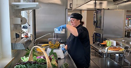 en kock står och jobbar i ett skolkök