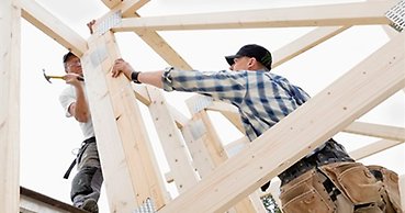 två snickare bygger på en husstomme