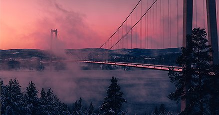 Höga Kustenbron i rosa kvällsskimmer och lätt dimma