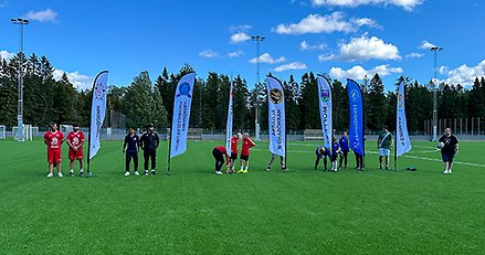 Föreningsrepresentanter och Andreas Sjölander på fotbollsplanen.