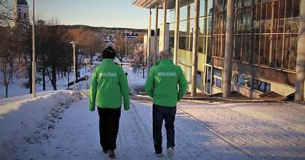 Två personer utomhus i Härnösand med jackor där det står "Vuxna på stan".