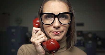 kvinna som håller en telefonlur vid örat