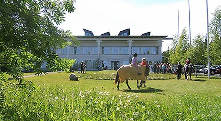 Länsmuseet Västernorrlands huvudbyggnad i bakgrunden och barn på häst i förgrunden.