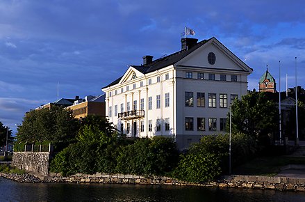 Exteriör bild på residenset i Härnösand. Vitt stenhus. Foto taget från vattnet in mot torget.