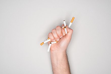 En hand som knycklar ihop ett par cigarretter.