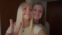 Två glada tjejer tittar in i kameran
