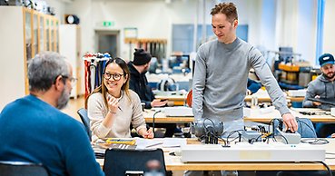 En glad tjej och kille i utbildningsmiljö.