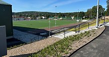 Konstgräsplan och skymten av en sporthall.