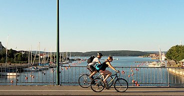Två cyklister cyklar på cykelbana över Nybron i centrala Härnösand.