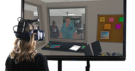En kvinna med VR-headset tittar på en skärm med datoranimerade figurer.
