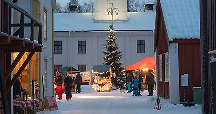 julmarknad på vintrigt torg på LÄnsmuseet Västernorrland på Muberget, marknadsstånd och människor