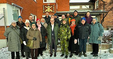 många människor står framför en röd tegelbyggnad